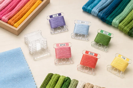 Clear acrylic Hamtery bobbins with floss and microfiber cloth arranged for gentle care